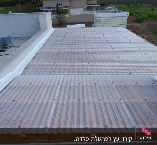 גג פלסטיק שקוף עם ברגים על מסגרת עץ